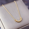 Elegant gold snake chain necklace with seven matte geometric beads in a jewelry box - Eight Cubes (H318) Gold