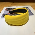 Padded bright yellow sponge headband with thick knit fabric on a vintage magazine - Ginger Yellow
