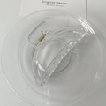 Makro-Detail einer transparenten Haarklammer aus Acryl mit goldenem Metallfedermechanismus - Groß / Transparent