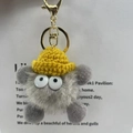 Detail of grey fluffy plush keychain with yellow knit hat and golden lobster clasp - Grey with Yellow Hat