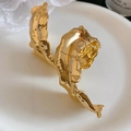 Macro-opname van gouden lava-armband met onregelmatige organische metaalvouwen - Bladstijl / Goud