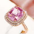 Macro shot of cushion-cut pink gemstone ring with halo diamonds on rose gold band - Pink+Rose Gold
