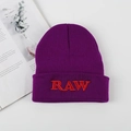 Dark purple beanie featuring bold red RAW embroidery with a classic streetwear look - One Size / Purple