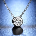 Classic silver necklace with 1-carat round brilliant moissanite pendant on blue background - Q009 Bezel Set 1ct