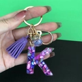 Resin initial K keychain with colorful shell flakes and purple suede tassel charm - Letter K