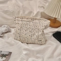 Detailed shot of floral canvas makeup bag on a soft fabric background with lifestyle props - Small Black Floral