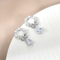 Dettaglio di orecchini a fiocco in argento con perle eleganti e zirconi a forma di goccia - Argento