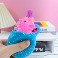 Blue dinosaur egg squeeze toy with pink dinosaur popping out for stress relief - Dinosaur Egg Squeeze Toy