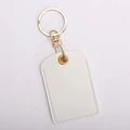 Close-up of white leather access card holder keychain with gold hardware and fine stitching - Square / Pearl White