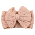 Detail of baby nylon headband featuring a large dusty pink cable knit bow - Blush