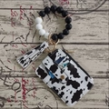 Detail of cow print card holder wallet with silicone bead wristlet and gold hardware - Cow Print