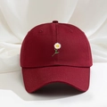 Dettaglio della margherita ricamata su un cappello di cotone bordeaux con visiera curva - Borgogna