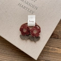 Close-up of handmade crochet flower hair ties with burgundy petals and green leaves - Dark Red Flower Hair Tie
