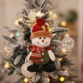 Christmas snowman plush ornament hanging on decorated tree with festive warm lighting - Snowman
