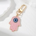 Detail of pink enamel Hamsa Hand keychain with blue Evil Eye and golden clasp - Pink Hamsa Hand