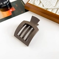 Detail of coffee brown matte hair claw clip with cutout stripes in a warm setting - Matte Dark Coffee