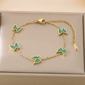 Macro view of gold butterfly bracelet with green malachite-style pendants in a jewelry box - Green (KB187209-BI)