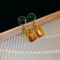 Detailed macro view of retro U-shaped earrings with green resin and amber stone drops - Silver Earring Post Style / Gold Green Coffee Combination