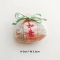 Macro detail of pink satin embroidered fortune bag accessory with Ruyi character and bow - Champagne Pink (Ruyi)