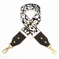 Detail of leopard print wide strap with black leather ends and gold metal hardware hooks - White