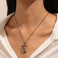 Gothic bronze rose heart necklace worn by a model against a clean beige backdrop - Antique Gold Floral Letter E/P (8471)