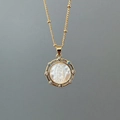 Macro shot of gold portrait necklace with mother of pearl and inlaid zircon detail - Style B (Round Mary - Colorful Zircon)