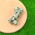 Carved natural crystal bone ornament with green and black spots on wood tray - Tianshan Blue