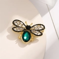 Détail macro de la broche abeille avec grande pierre verte et ailes en cristaux - Vert