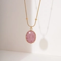 Elegante goldene Halskette mit großem ovalem rosa Steinanhänger auf weißem Grund - 18K-Gold / Rosa Rhodochrosit Ovaler Stil (NMSN-B339-1)