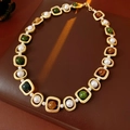 Dettaglio della collana vintage con perle e pietre verdi su fondo in pelle scura - Collana Oro Colorato