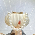 Elegant off-white pleated evening clutch bag with large pearl handle and gold bow clasp - Apricot