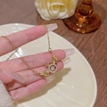 Collana in acciaio al titanio con pendente a doppia ala dorata e cristalli di zircone - Stile Ciondolo Anello a Doppia Ala (X264) / Oro