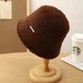 Detalle de gorro de pescador en sherpa marrón con acabado texturizado y etiqueta lateral - café