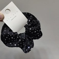 Detail of black satin hair scrunchie with sparkling crystals and brand tag - Black