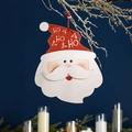 Detail of glitter Santa ornament with HO HO HO text and red string on a dark background - No. 7 Large Santa Claus Tag