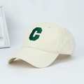 Detailed macro view of green C letter 3D embroidery on cream cotton baseball cap fabric - One Size Adjustable / White