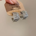 Dettaglio orecchini a C argentati con texture stropicciata su cartoncino espositivo - Perno in Argento S925 / Argento