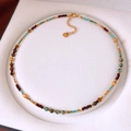 Detail shot of a bohemian beaded necklace with colorful stones in a white jewelry gift box - Colorful