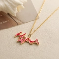 Macro detail of golden Hope pendant with pink ribbon design and small butterfly - Pink HOPE Butterfly