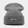 Detailed close-up of dark grey knitted beanie with white cursive embroidery on cuff - Dark Gray