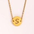 Détail d'un collier doré avec pendentif rond évidé lettre S et chaîne à mailles fines - Lettre S