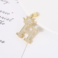 Macro detail of crown letter H pendant with pavé cubic zirconia and gold plating - Letter H