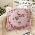 Pink jacquard pillow with floral embroidery and decorative pom-pom trim on sofa - Rose Red