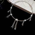 Detailansicht eines silbernen Perlenchokers mit zarten Metallfransen auf einem Schmuckhalter - Silber