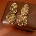 Dettaglio di orecchini vintage color oro champagne con cristalli su base in pelle - Oro Antico