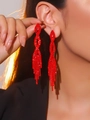 Elegant red rhinestone long tassel earrings shown on a model with a sparkling finish - True Red Full Rhinestone Vertical Tassel