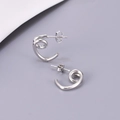 Macro view of silver spiral geometric stud earrings with secure butterfly backing - Steel