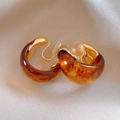 Close-up of amber resin hoop earrings with golden metal clip and silicone pads - Gold Brown Amber Clip-on Style (55#)