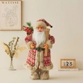 Handcrafted standing Santa Claus figurine holding skis in cozy red patterned robe - Sled Carrying Ski Style / 60cm Height