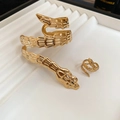 Detail of gold snake jewelry set with textured scales on a white display box - Gold